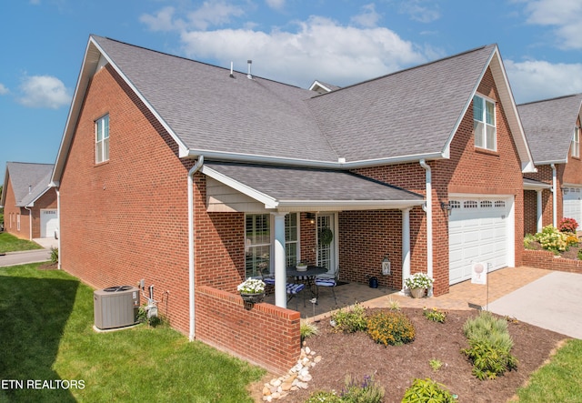 view of front of house featuring a shingled roof, central AC, brick siding, and driveway