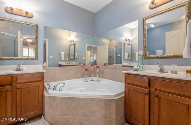 bathroom with two vanities, a sink, a shower stall, and a bath