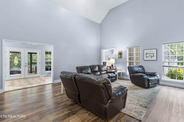 living room featuring high vaulted ceiling, french doors, wood-type flooring, and a wealth of natural light