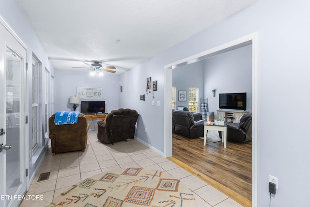 living room with ceiling fan and light tile patterned floors