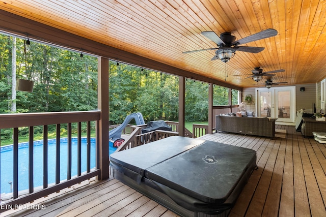 deck with a pool and ceiling fan