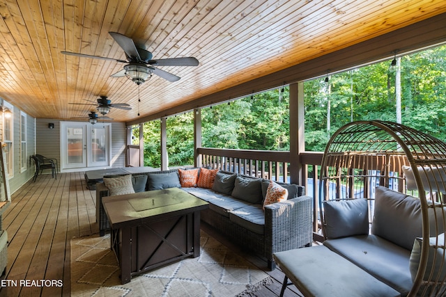 wooden terrace with ceiling fan and an outdoor hangout area