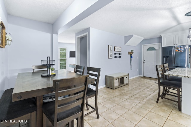 tiled dining space with a textured ceiling