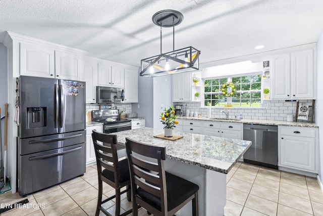 kitchen featuring white cabinets, a kitchen island, and stainless steel appliances