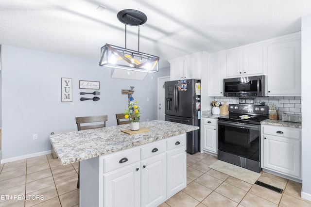 kitchen with electric stove, decorative backsplash, a center island, white cabinetry, and black fridge