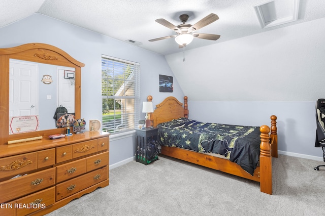 carpeted bedroom featuring ceiling fan, vaulted ceiling, and a textured ceiling