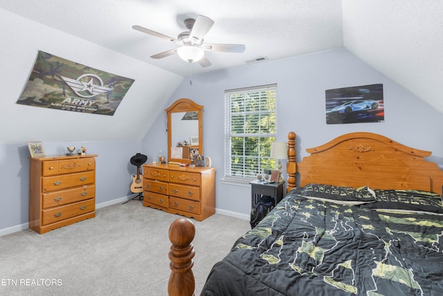 bedroom with lofted ceiling, light carpet, a textured ceiling, and ceiling fan