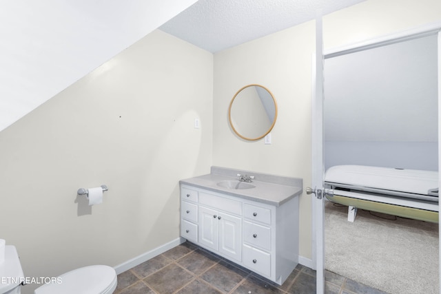 bathroom featuring vanity, tile patterned flooring, toilet, and a textured ceiling