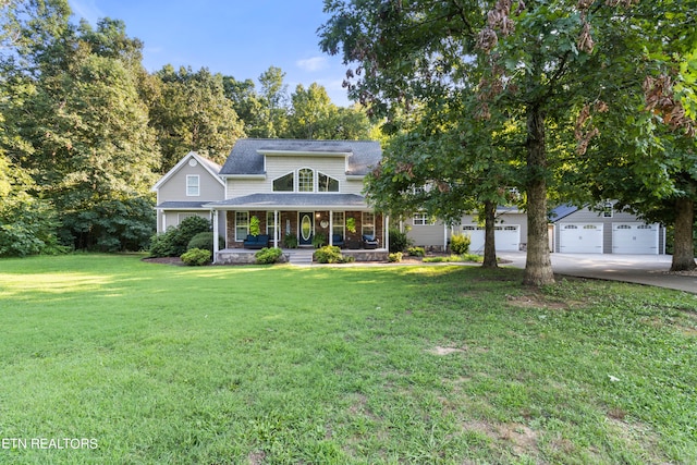 view of front of house with covered porch, a garage, and a front yard