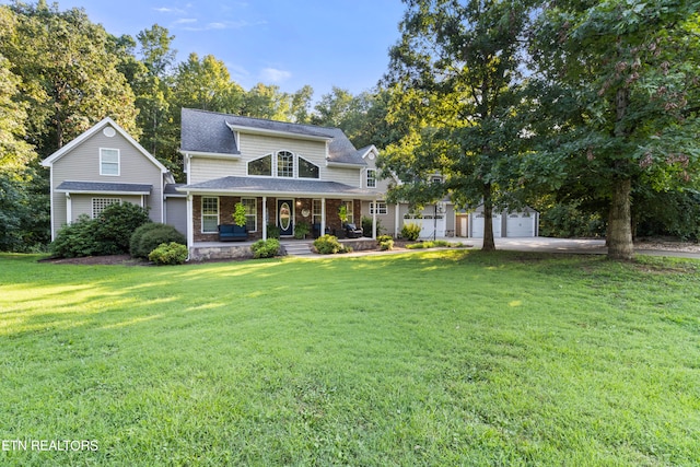 view of front of home featuring a garage, a front yard, and covered porch