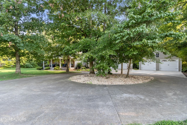 view of property hidden behind natural elements featuring a garage