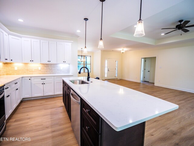 kitchen with light wood-type flooring, sink, an island with sink, and white cabinets