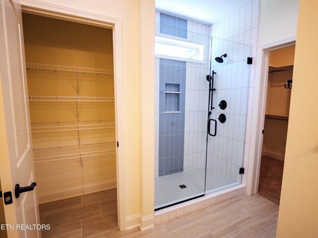 bathroom featuring tile patterned floors and a shower with door