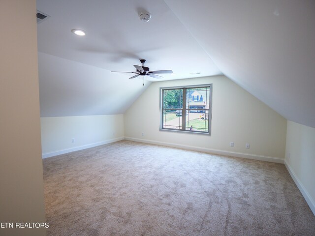 additional living space featuring ceiling fan, light colored carpet, and lofted ceiling