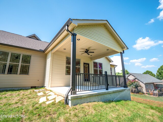 view of front of house featuring ceiling fan and a front lawn