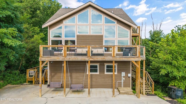 back of property featuring a patio and a wooden deck