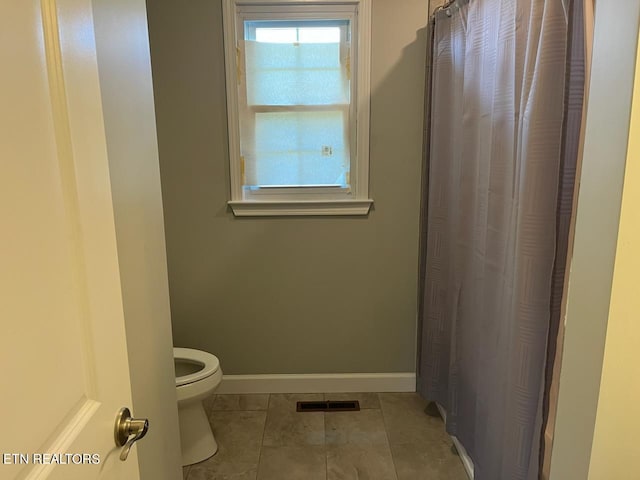 bathroom featuring toilet and tile patterned flooring