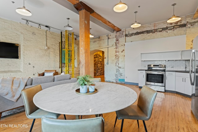 dining room with light wood-type flooring and rail lighting