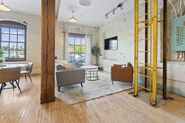 living room with hardwood / wood-style floors, track lighting, and plenty of natural light