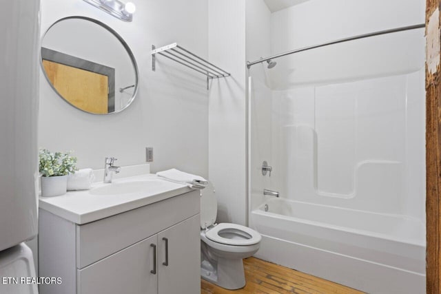 full bathroom with shower / washtub combination, toilet, vanity, and hardwood / wood-style floors