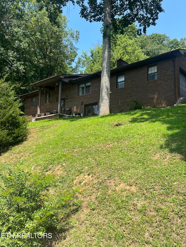 rear view of property featuring a lawn