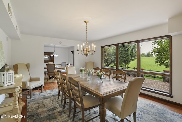 dining area with hardwood / wood-style flooring and a notable chandelier