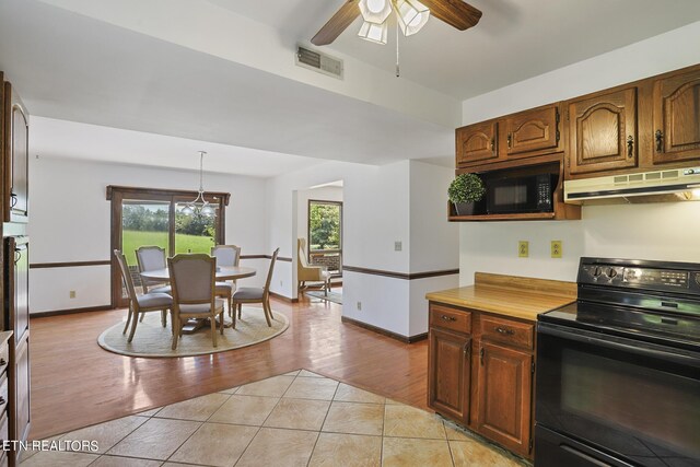 kitchen with ceiling fan, hanging light fixtures, black appliances, and light hardwood / wood-style floors