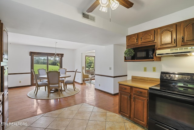 kitchen featuring pendant lighting, ceiling fan, light tile patterned floors, and black appliances