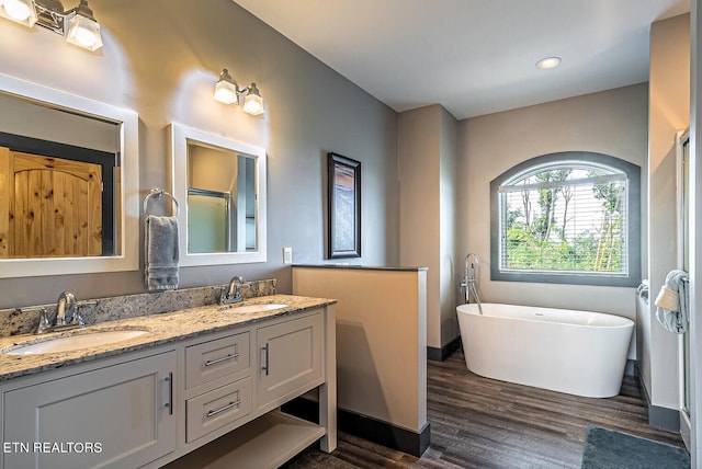 bathroom with dual vanity and wood-type flooring