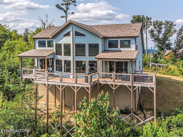 rear view of property featuring a wooden deck