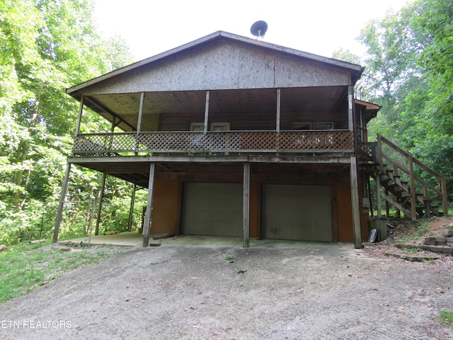 view of front facade with a carport, driveway, stairway, and an attached garage