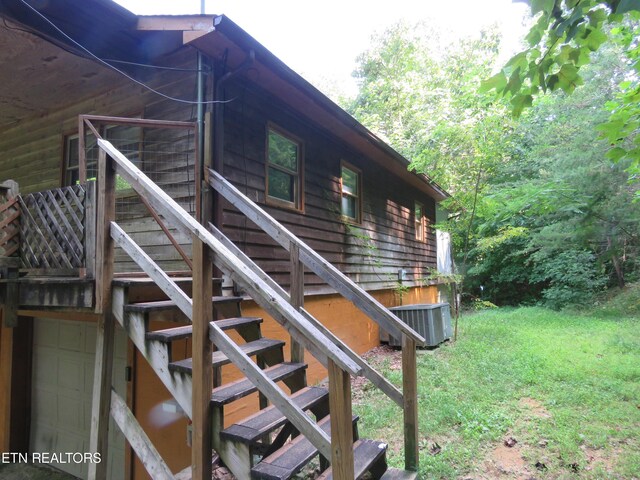 exterior space featuring central air condition unit and a lawn