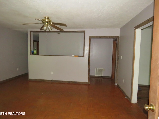 empty room with a ceiling fan, baseboards, visible vents, and a textured ceiling