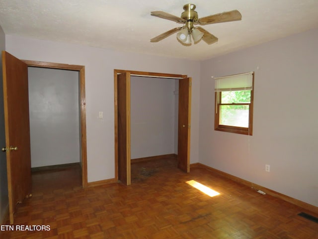 unfurnished bedroom with baseboards, visible vents, ceiling fan, and a closet