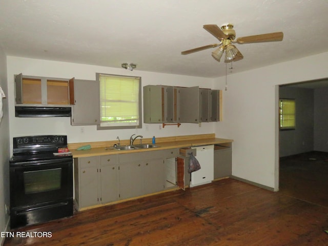 kitchen featuring white dishwasher, light countertops, black electric range, under cabinet range hood, and a sink