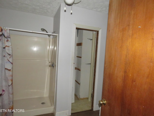 full bathroom with a textured ceiling and curtained shower