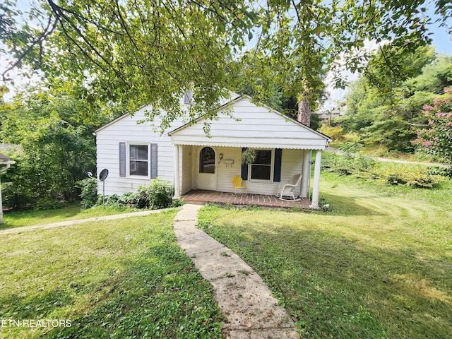 bungalow with a porch and a front lawn