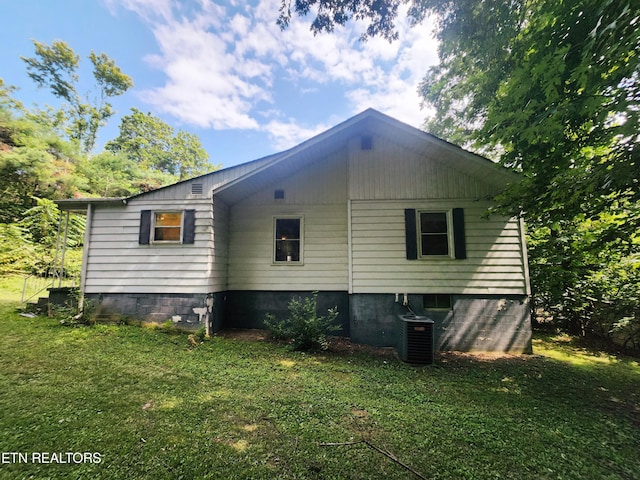 view of property exterior featuring central AC unit and a lawn