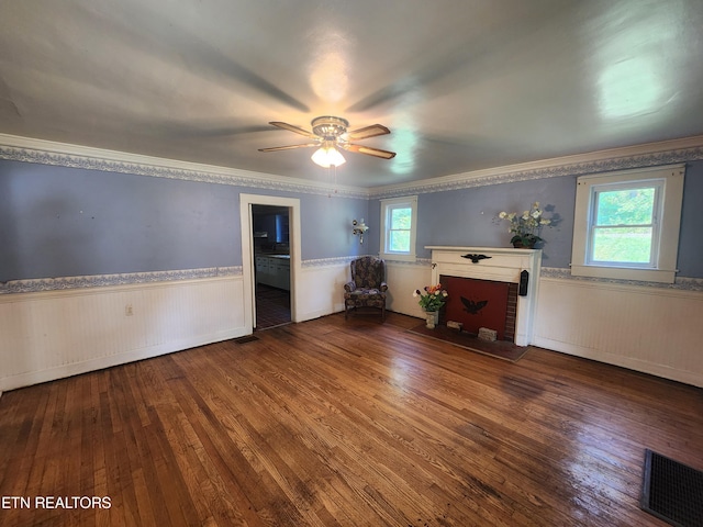 unfurnished living room with hardwood / wood-style floors, a fireplace, ornamental molding, and ceiling fan