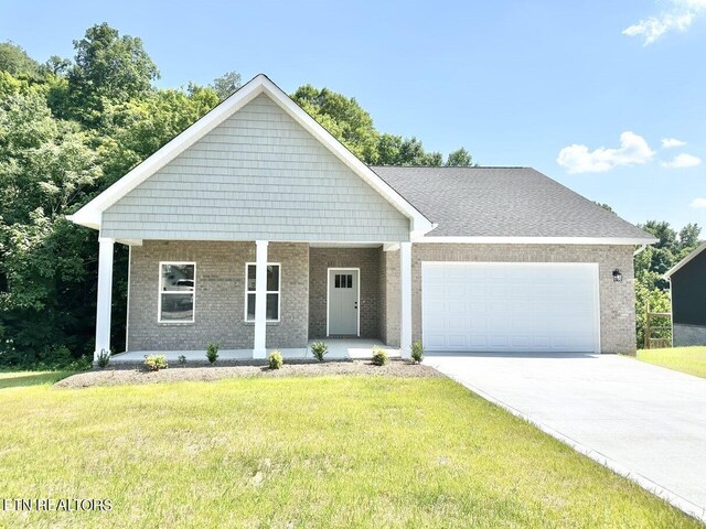 view of front facade featuring a garage, a front yard, and covered porch