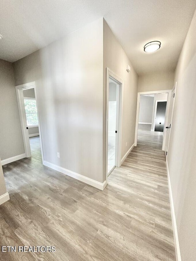 hall with a textured ceiling and hardwood / wood-style flooring