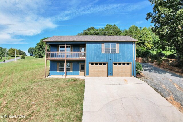 view of front facade featuring a garage, a front yard, and covered porch