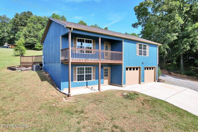 view of front facade featuring a front lawn, a garage, and central AC unit