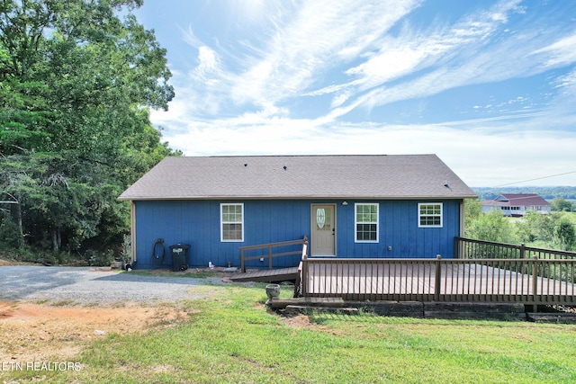 view of front of house featuring a front lawn and a deck