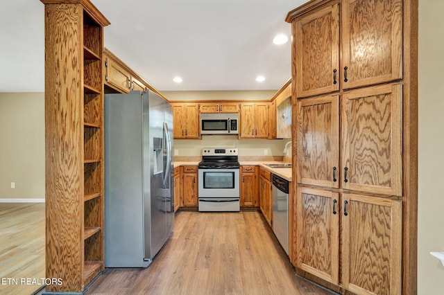 kitchen featuring hardwood / wood-style floors, stainless steel appliances, and sink