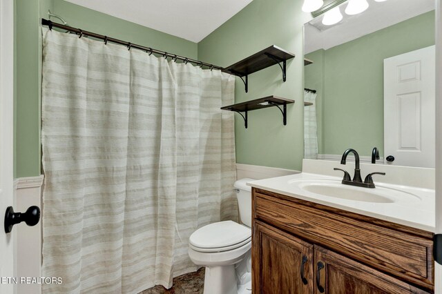 bathroom featuring vanity, toilet, and walk in shower