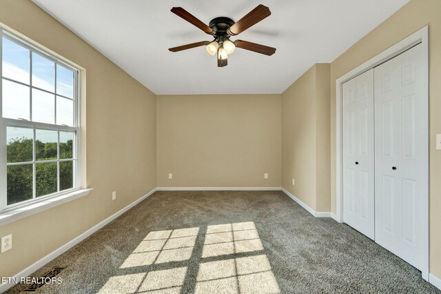 unfurnished bedroom featuring carpet flooring, ceiling fan, and a closet