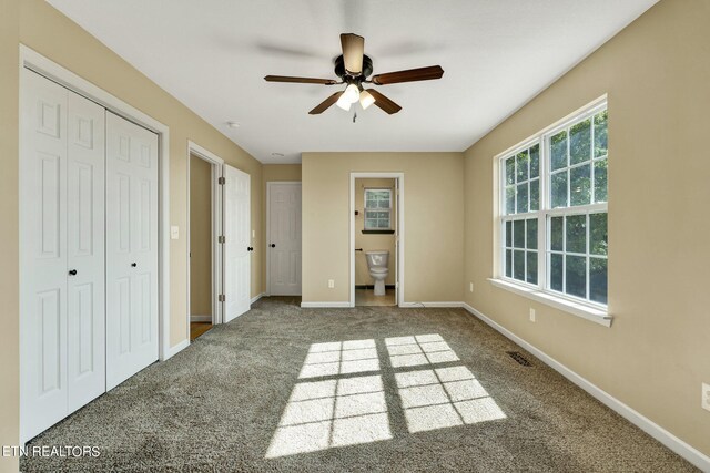 unfurnished bedroom featuring ceiling fan, ensuite bath, and carpet floors