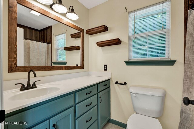 bathroom featuring a wealth of natural light, vanity, and toilet