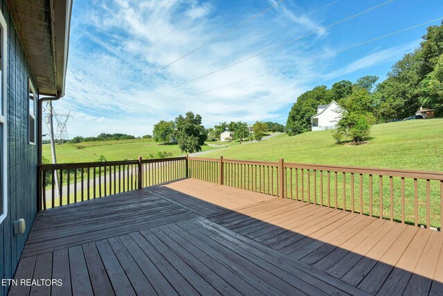 wooden terrace featuring a lawn